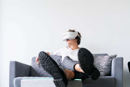 Man wearing virtual reality goggles in modern bright co-working office. the VR experience.の写真素材