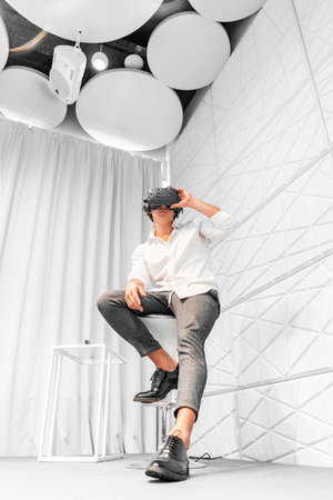 Man wearing virtual reality goggles in modern bright co-working office. the VR experience.の写真素材