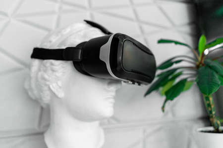 Close up of plaster bust wearing virtual reality goggles.の写真素材