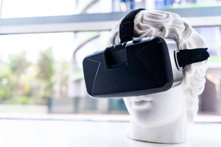Close up of plaster bust wearing virtual reality goggles.の写真素材