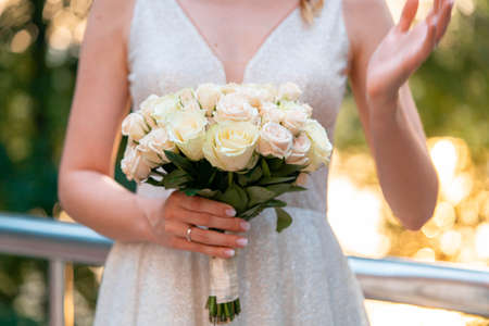 Close up of Wedding bouquet in hands of bride in wedding day outdoors at park.の写真素材