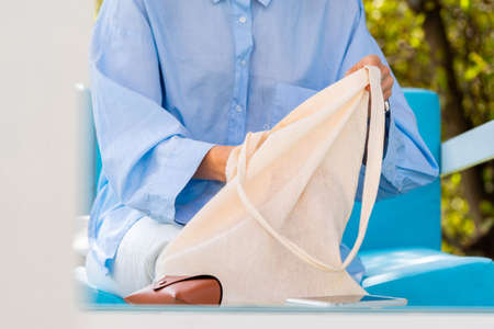 Close up of coffee eco biodegradable cup and cotton blank white canvas bag. Eco friendly take away mug and bag.の写真素材