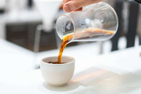 process of preparation black coffee in pour over coffee maker in bright modern cafe. Alternative ways of brewing coffee.の写真素材