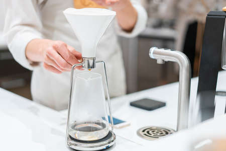 process of preparation black coffee in pour over coffee maker in bright modern cafe. Alternative ways of brewing coffee.の写真素材