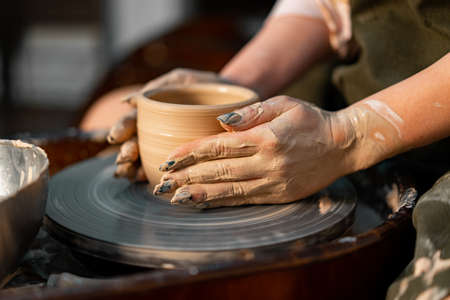 Woman Potter Hands Shaped Mug From Clay. The Process of Creating Pottery On a Potter's Wheel. The...