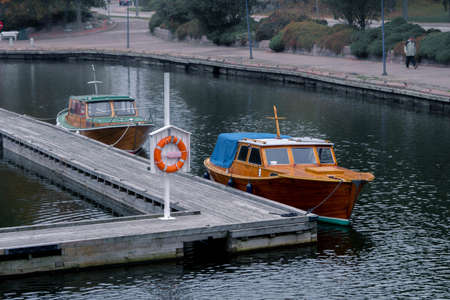 Little Wooden Yacht Moored At Pierce In Finland Near Riverside. Travelling By Water. Vacation in...