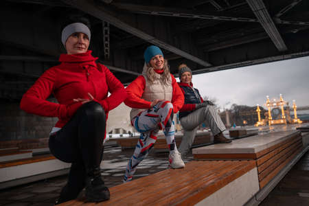 Healthy Middle Aged Women Warming Up And Stretching Legs Outdoors. Active Lifestyle Of Mature Womenの写真素材