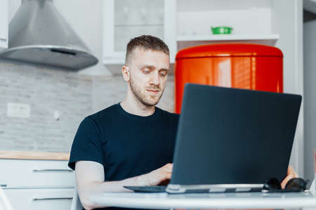 Pensive Businessman Working On Laptop from Home. Working And Living In Quarantine. Coronavirus. Modern Technologies. Cozy Home Interiorの写真素材