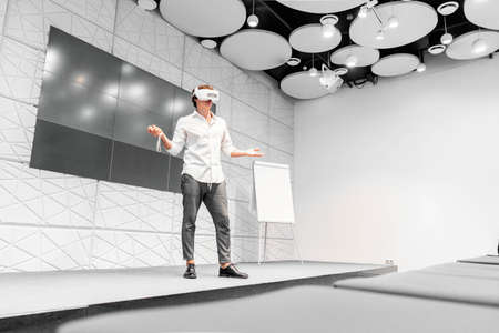 Man Wearing Virtual Reality Goggles and Speaking at Scene Without Viewers. Living And Working In...