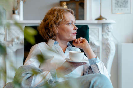 Stay Home. Close up Of Beautiful Senior Woman Drinking Tea At Living Room Alone. Aged People In Time Of Quarantine And Isolationの写真素材