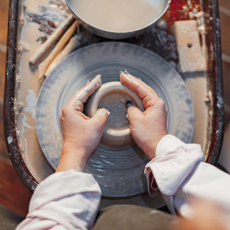 Close up of Woman Hands Working on Pottery Wheel With Clayの写真素材