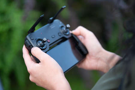 Close up of Woman Holding Joystick Remote Controller of Wireless Quadcopter Drone With Video and Photo Camera For Aerial Photographyの写真素材