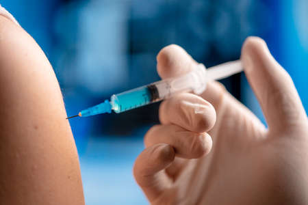 Close Up Of Doctor Vaccinating Patient With Syringe Injection. Vaccine and Medicine Trial. Prevention, Immunization From Virus In Modern Hospitalの写真素材