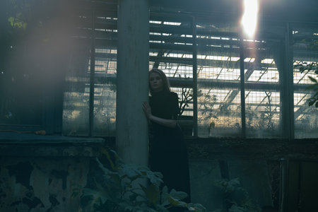Beautiful Blond Girl Near Abandoned Houseplant At Gothic Park. Concept Of Doubts, Depression, and Loneliness.の写真素材