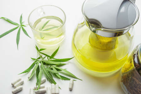 A hot drink made by infusing the fresh leaves of the marijuana leaf in boiling water. Beverage ganja in glass cup for drink. Concept alternative herbs for healing.の写真素材