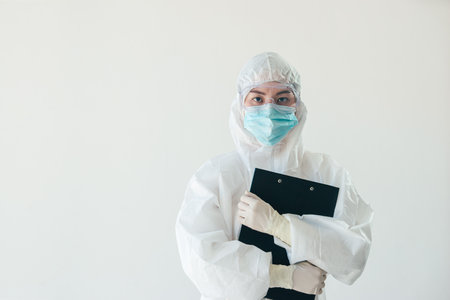 Asian medical staff holding report in personal protective equipment or PPE  working on quarantine patient infected in during the epidemic crisisの写真素材