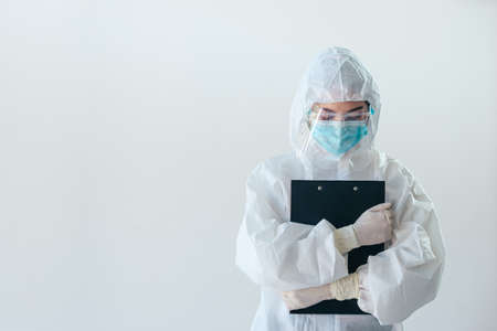 Asian medical staff holding report in personal protective equipment or PPE  working on quarantine patient infected in during the epidemic crisisの写真素材