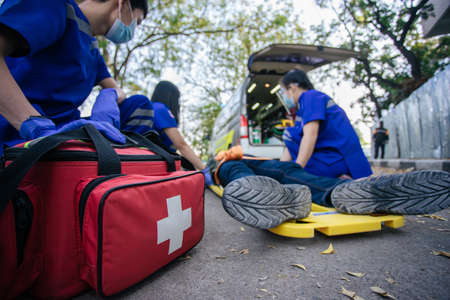 Selective focus is first aid bag. Team paramedic firs aid accident on road. Ambulance emergency...