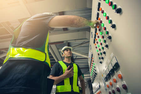 Two Electrical Engineer team working front control panel, Engineer training job with control panel in service room.の写真素材