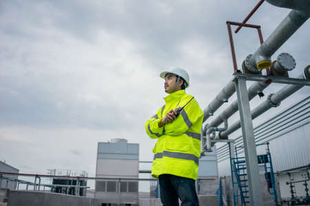 Mechanical Engineer working install chilled water pipe in site work under storm clouds.の写真素材