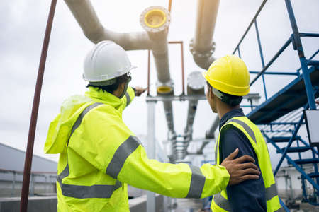 Mechanical engineer working install chilled water pipe system. Engineer consult discussion with team...