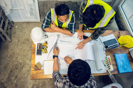 Contractor meeting plan work with drawing factory, Engineer working overtime.の写真素材
