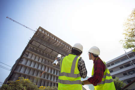 Two man civil engineering in Hard Hats Discuss in site work.の写真素材