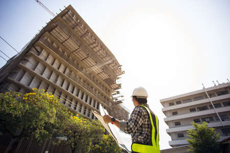 Civil engineering in Hard Hats check drawing in site work.