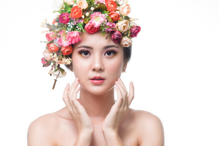 Portrait of beautiful young asian woman with flowers. Brunette woman with luxury makeup. Perfect skin. Eyelashes. Cosmetic eyeshadow. Perfect Creative Make up and Hair Style.の写真素材