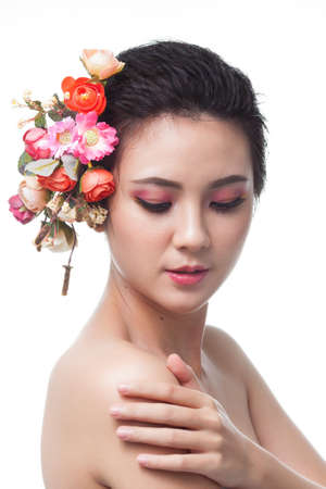 Portrait of beautiful young asian woman with flowers. Brunette woman with luxury makeup. Perfect skin. Eyelashes. Cosmetic eyeshadow. Perfect Creative Make up and Hair Style.の写真素材