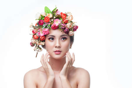 Portrait of beautiful young asian woman with flowers. Brunette woman with luxury makeup. Perfect skin. Eyelashes. Cosmetic eyeshadow. Perfect Creative Make up and Hair Style.の写真素材