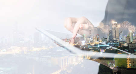 Double exposure business people working on digital tablet in the cityscape.の写真素材