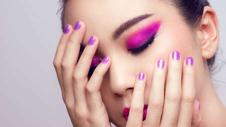 Asian female closeup colorful eyeshadow with extreme long false eyelashes. Eyelash Extensions. Makeup, Cosmetics, Beautiful cosmetics makeup concept.の写真素材