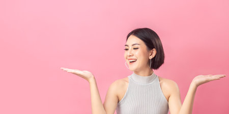 Beautiful portrait Asian woman short hair in studio pink background.の写真素材