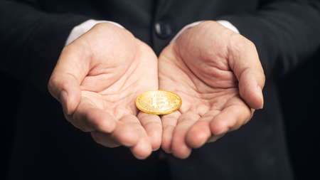 Selective focus cryptocurrency golden bitcoin coin on hand. Alternative finance and investment concept.の写真素材