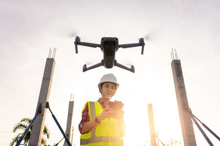 Asian woman engineer surveyor control drone for aerial view structure inspection in project...