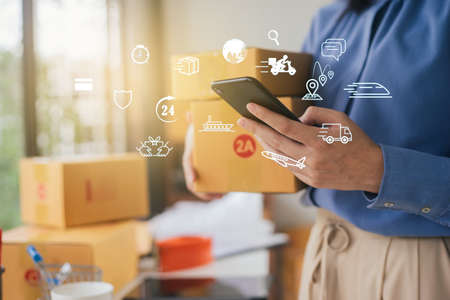 Close Up hand of businesswoman holding use smartphone contact transportation service for parcel...