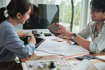 Two Asian Architect or Engineer discussing with spec material for design project. Architect or...