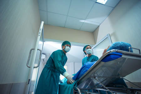Surgeon assistant team transport move stretcher the patient to operating room in hospital.