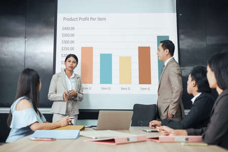 Businesswoman present job result in meeting room. Sale team present profit of business product. Presenter Asian female.の写真素材