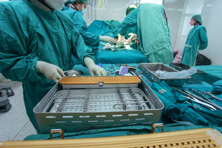 Selective focus, Assistant Orthopedic doctor preparing instruments for operation bone fracture on...