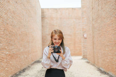 Traveler Asian woman happy smile taking photo in coliseum architecture at Surin Thailand after recovered from pandemic virus. Travel trip concept after pandemicの写真素材