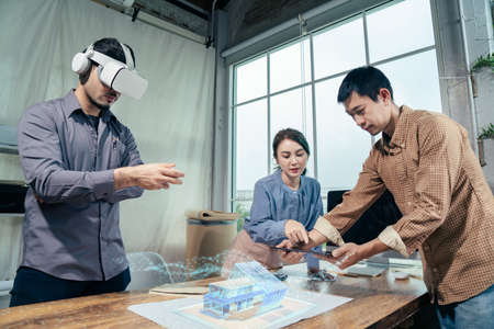 Asian people Architect team together design architectural building model with Virtual reality and...