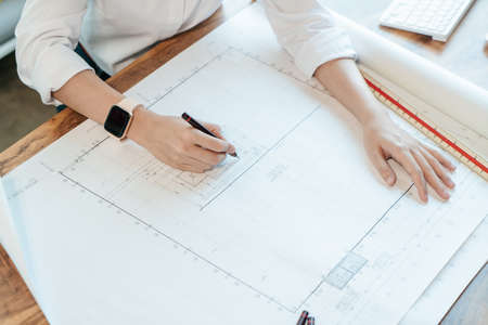 Selective focus, Engineer hand working writing detail on blueprint architecture. Top view Architect...
