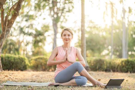 Beautiful young Asian woman happy smile healthy in sportswear workout practice yoga online with...