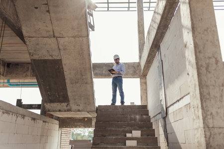 A man consult engineer inspection stair in construction project. Architect or Civil Engineer working inspection in construction site.の写真素材
