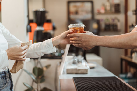 Waitress giving coffee cup  to customer at coffee shop. SME business coffee shop concept.の写真素材