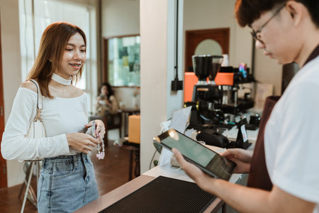 Waitress use digital tablet take order service customer at coffee shop. SME business coffee shop concept.の写真素材