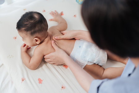 Top view, Baby back massage for stimulate development by mother. Mother makes massage for happy baby. Infant healthcare concept.の写真素材