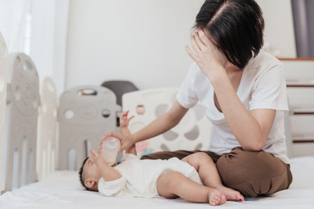 Tired Asian mother suffering from experiencing postnatal depression. Healthcare single mom motherhood stressful.の写真素材